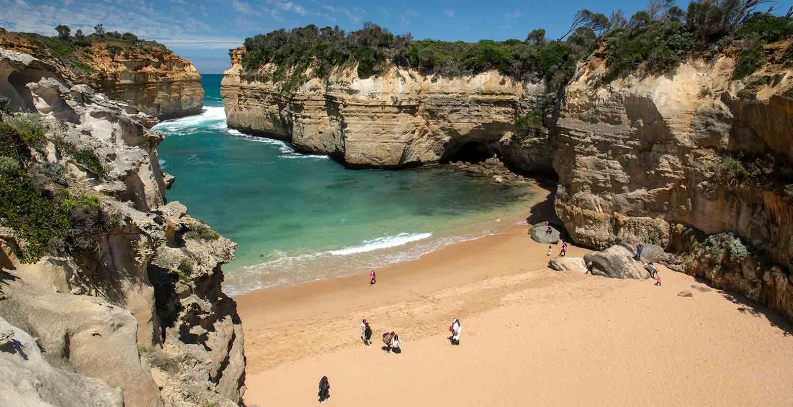 A view looking down of people on Loch Ard Gorge along the Great Ocean Road on a sunny day